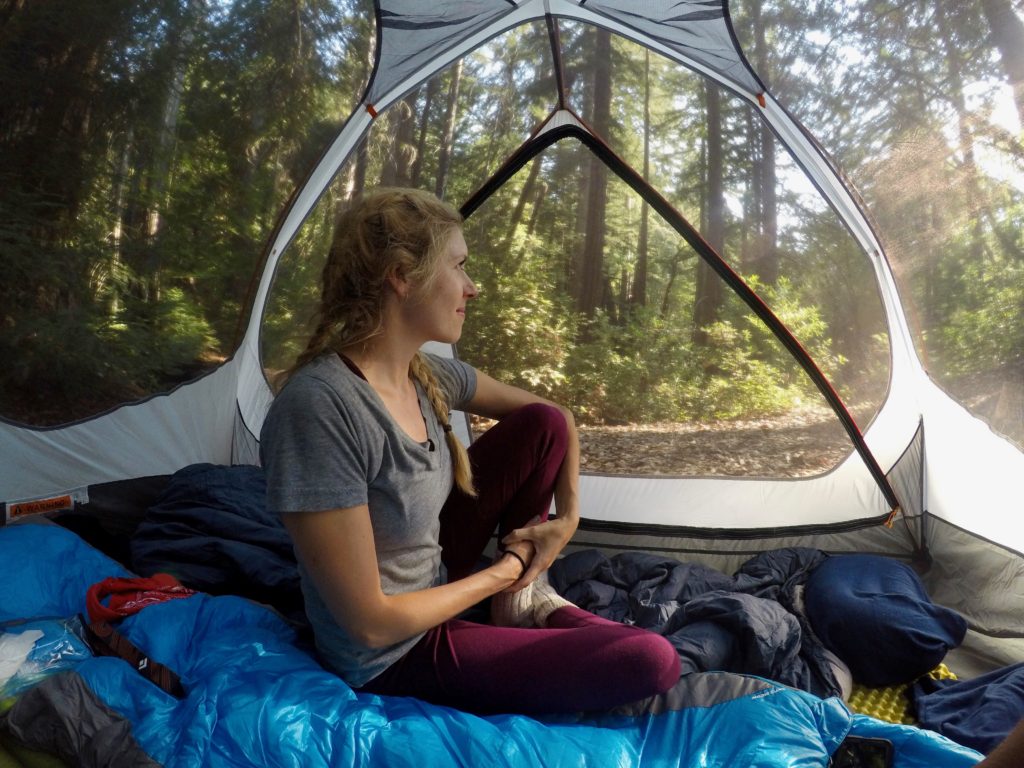 Girl sitting in tent with views of the trees