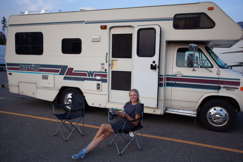 Chelsey sitting in front of her RV in the parking lot which was a free camping spot in the US