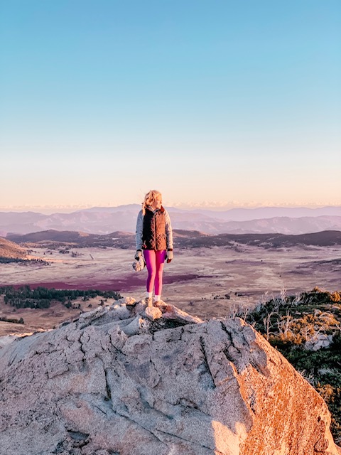 Girl on top of mountain in Julian watching a sunrise