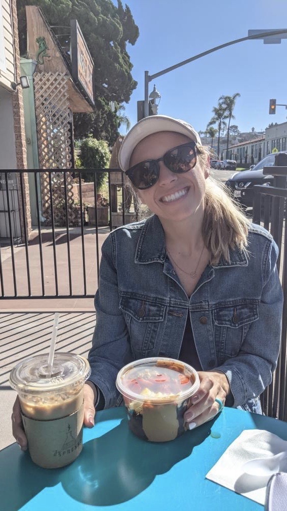 Chelsey holding a coffee and acai bowl outside of espresso Lab