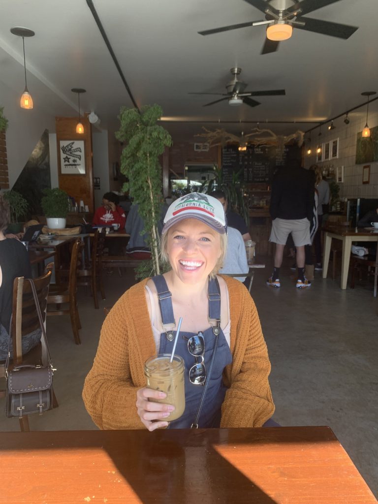 Chelsey holding a coffee at Bay Park Coffee in San Diego