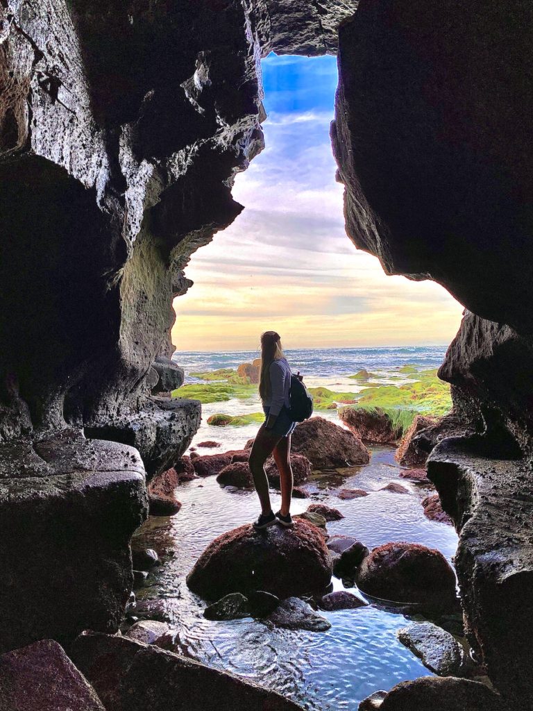 Girl in the sunset cliffs caves