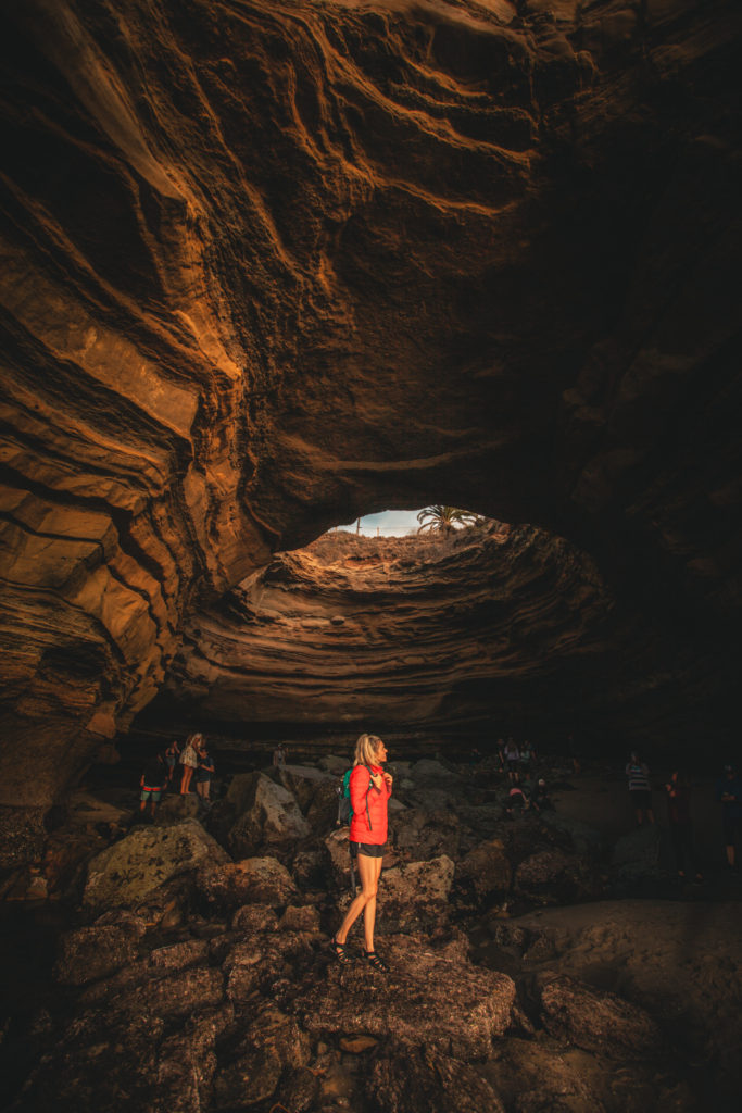 Girl inside the sunset cliffs sea cave which is a hidden gem to add to your San Diego itinerary