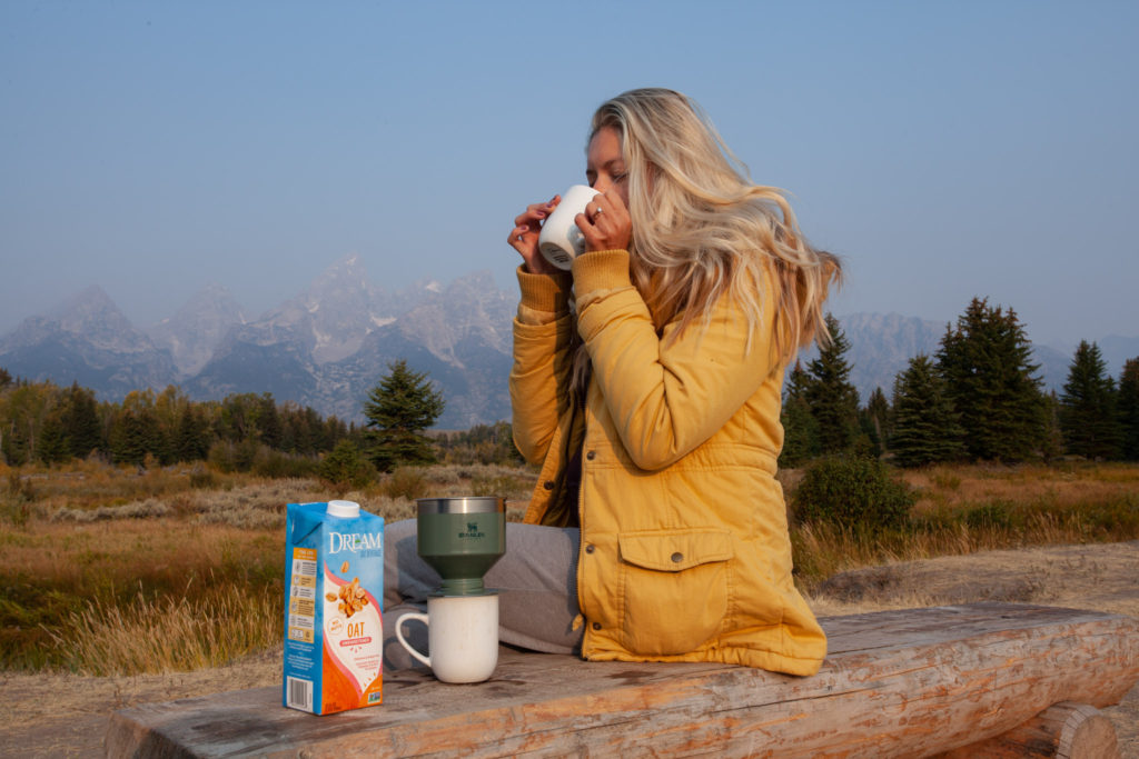 Girl drinking coffee in front of the Grand Tetons