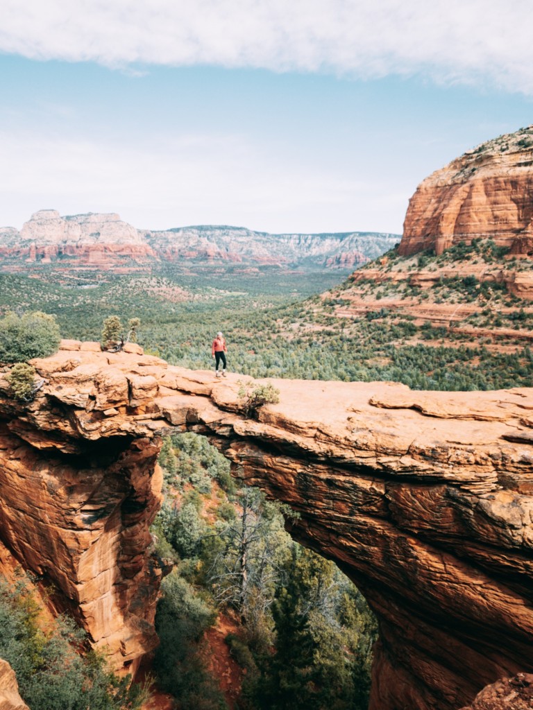 Girl standing on Devil's Bridge in Sedona which is a hike you must add to your Sedona travel trip