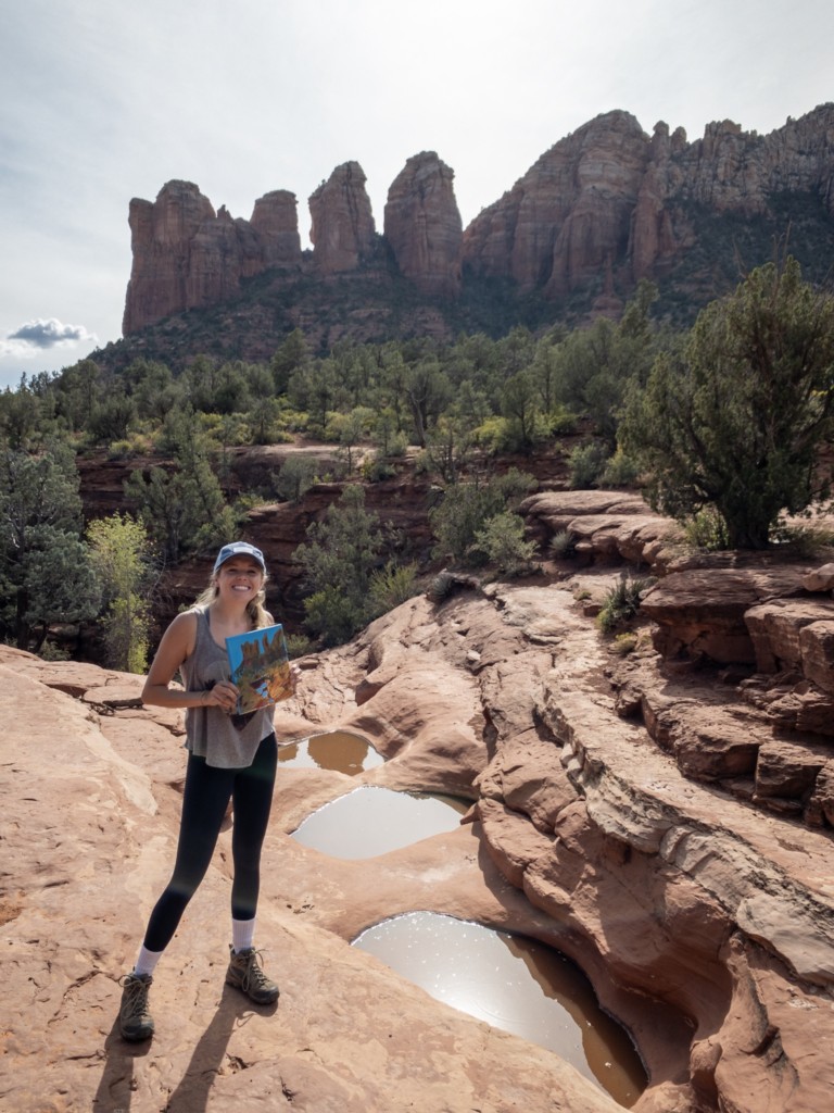 Girl holding a painting up in front of the seven sacred pools