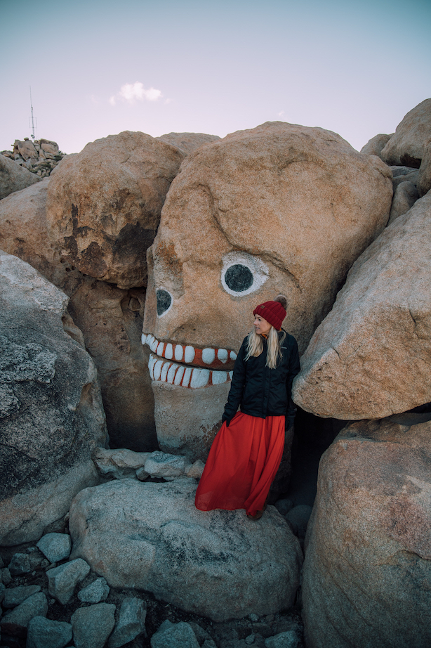 Girls standing in front of skull rock in boulder park 