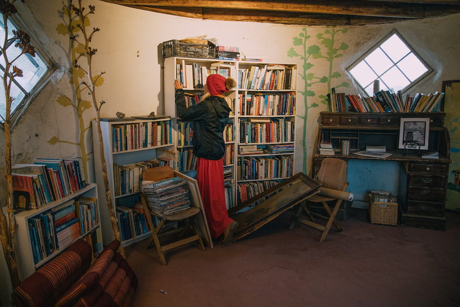 Girl looking through the bookshelf inside the desert view tower