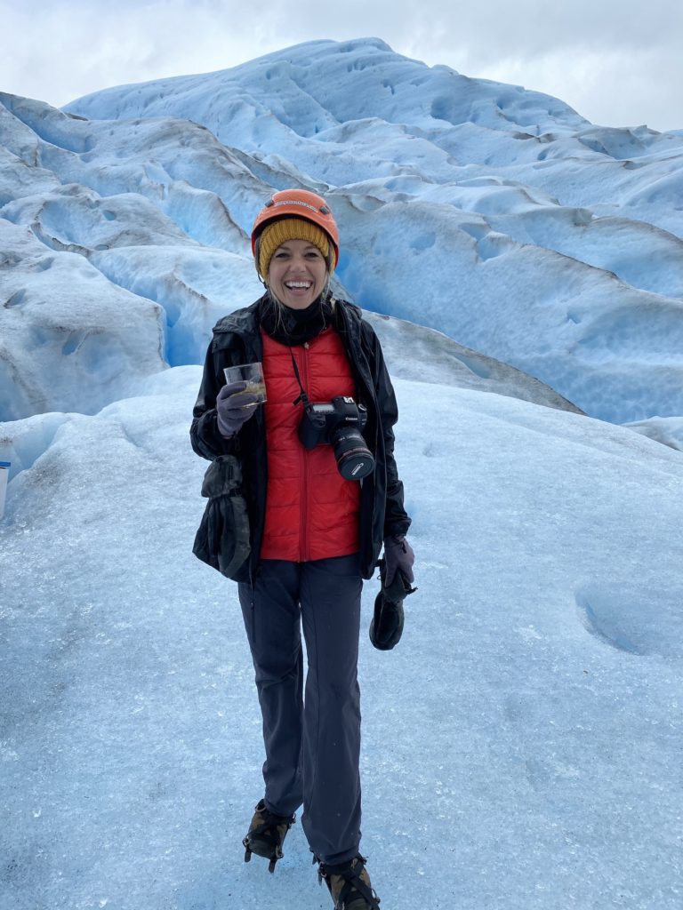 Girl holding a whiskey drink on the Perito Moreno Glacier