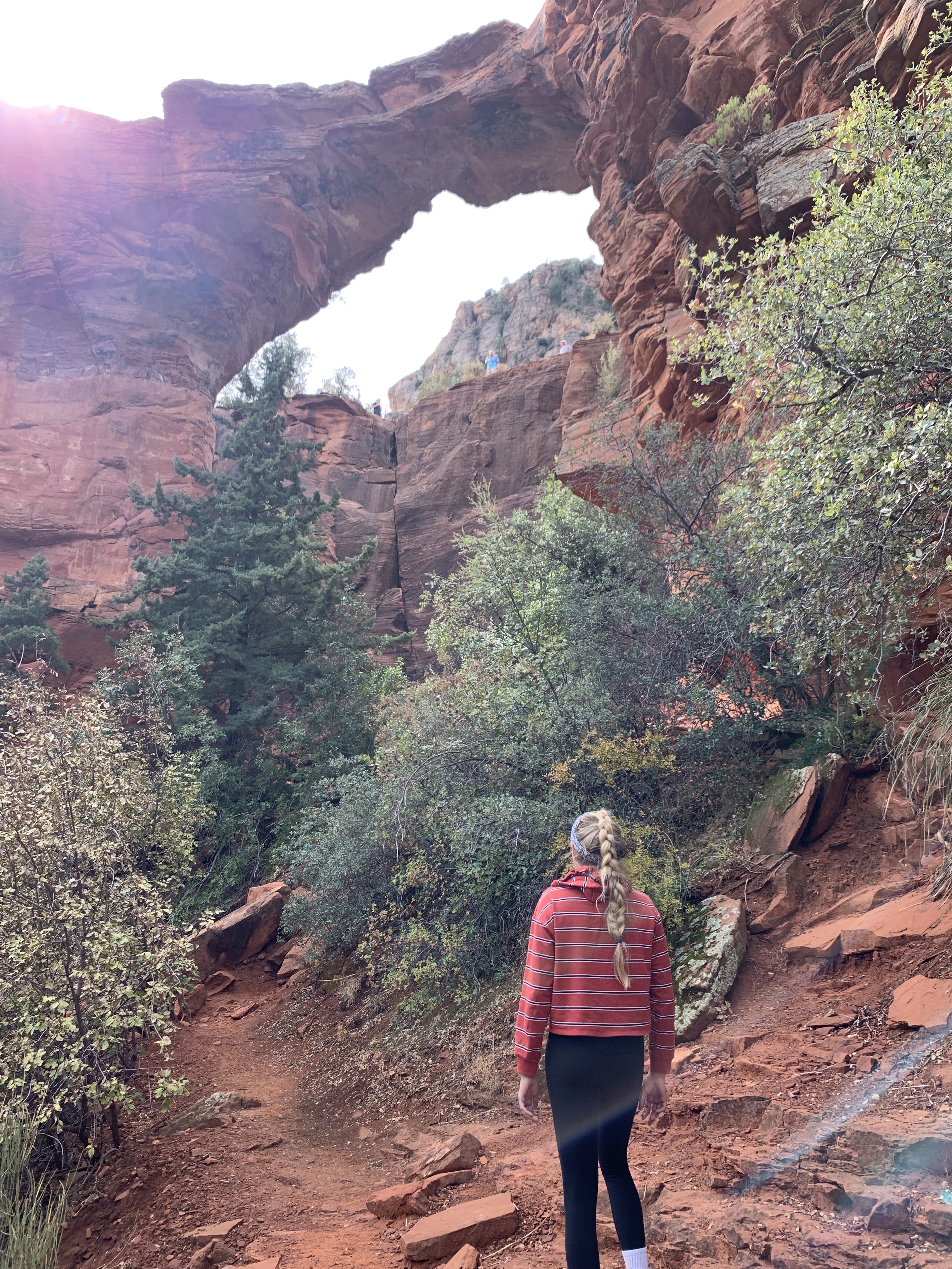 Girl standing under Devil's Bridge in Sedona