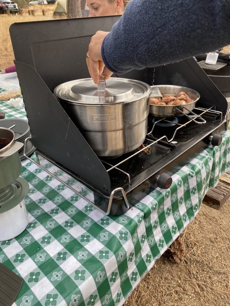 Cooking on a camp stove which is essential for camping