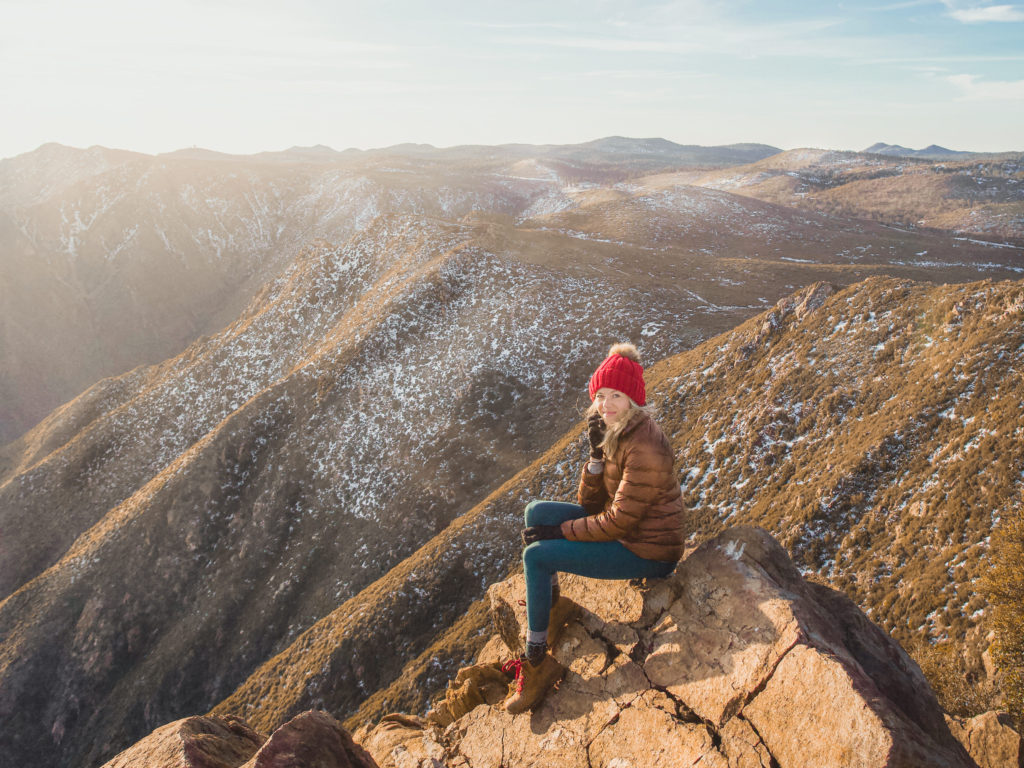 Girl sitting on the mountain in her hiking boots