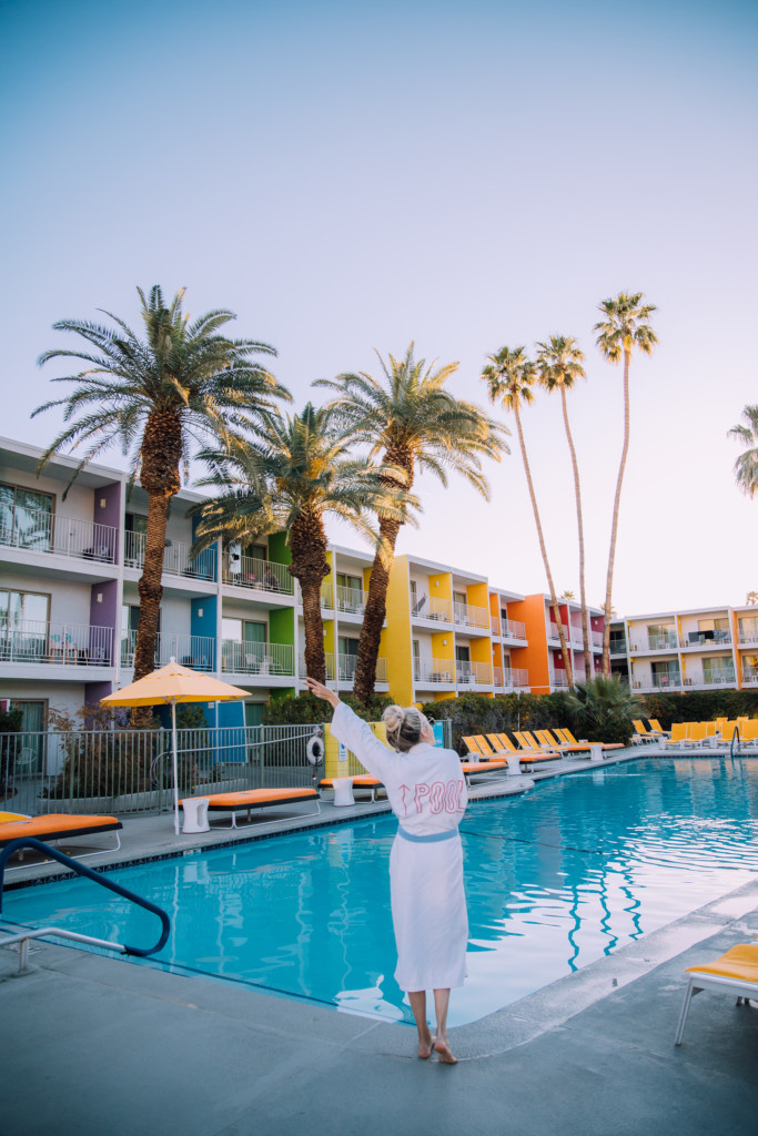 Girl standing in front of the pool at the Saguaro which is a hotel to stay at on your Palm Springs weekend getaway