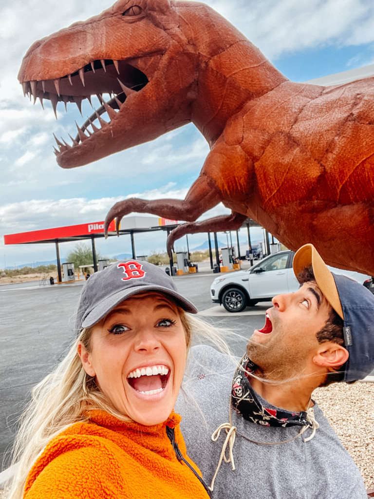Girl and guy standing in front of the dinosaur statues in Gila Bend