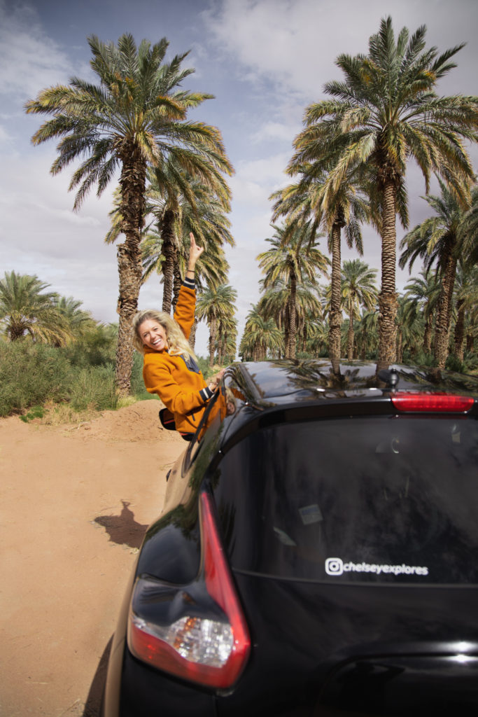 Girl in car with Palm Trees in background on her drive from San Diego to Phoenix