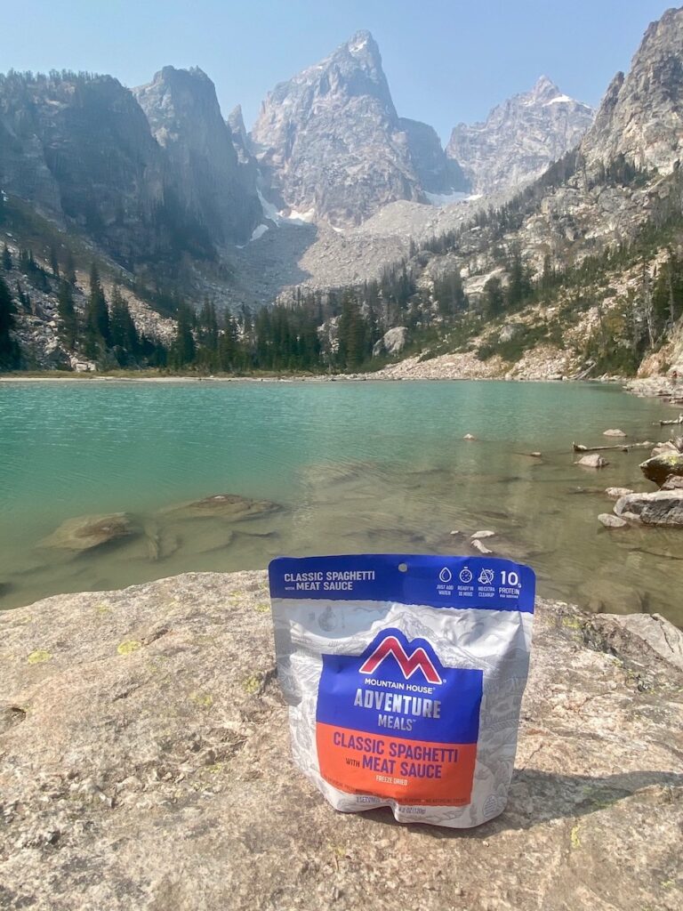 Backpacking food meal sitting on a rock in front of Delta Lake