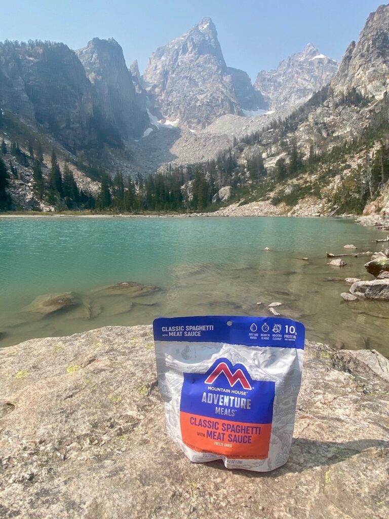 Backpacking food meal sitting on a rock in front of Delta Lake 