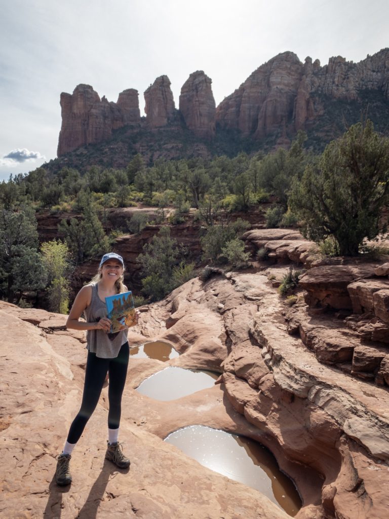 Girl holding an art piece in front of the seven sacred pools 