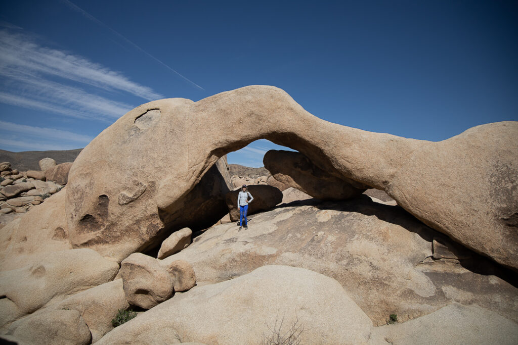 Chelsey standing in front of Arch Rock which one of the things to do in Joshua Tree National Park