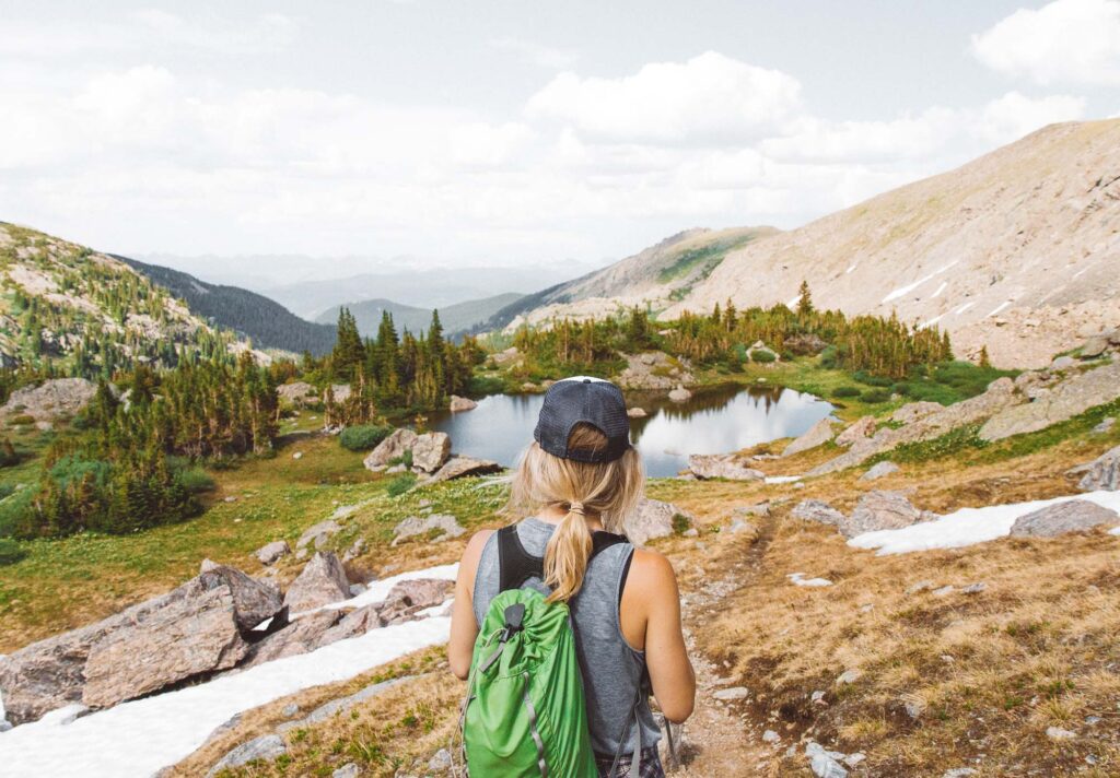 Blonde girl on a backpacking trip overlooking a lake