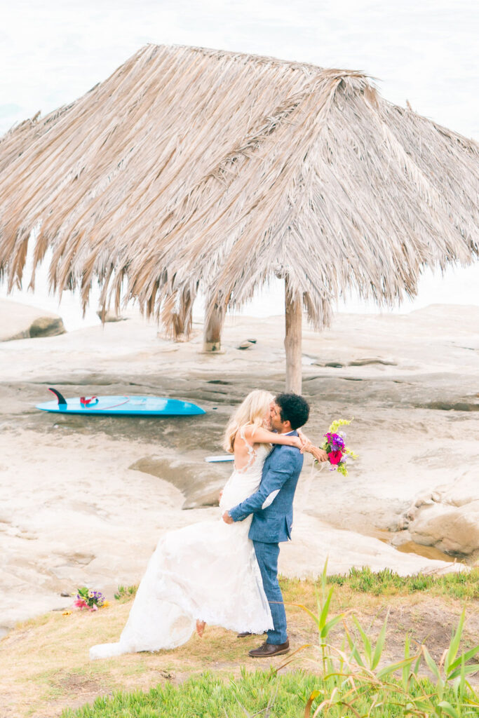 Wedding couple kissing in front of the hut in La Jolla 