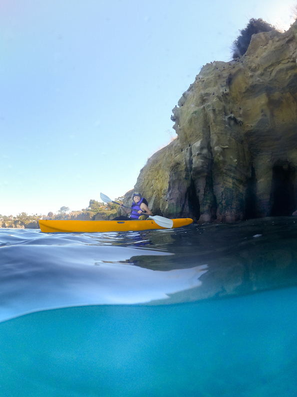 Girl kayaking in La Jolla which is a San Diego water sport