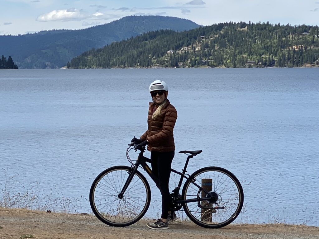 Girl biking the North Idaho Centennial Trail which is one of the best things to do in Coeur d’Alene