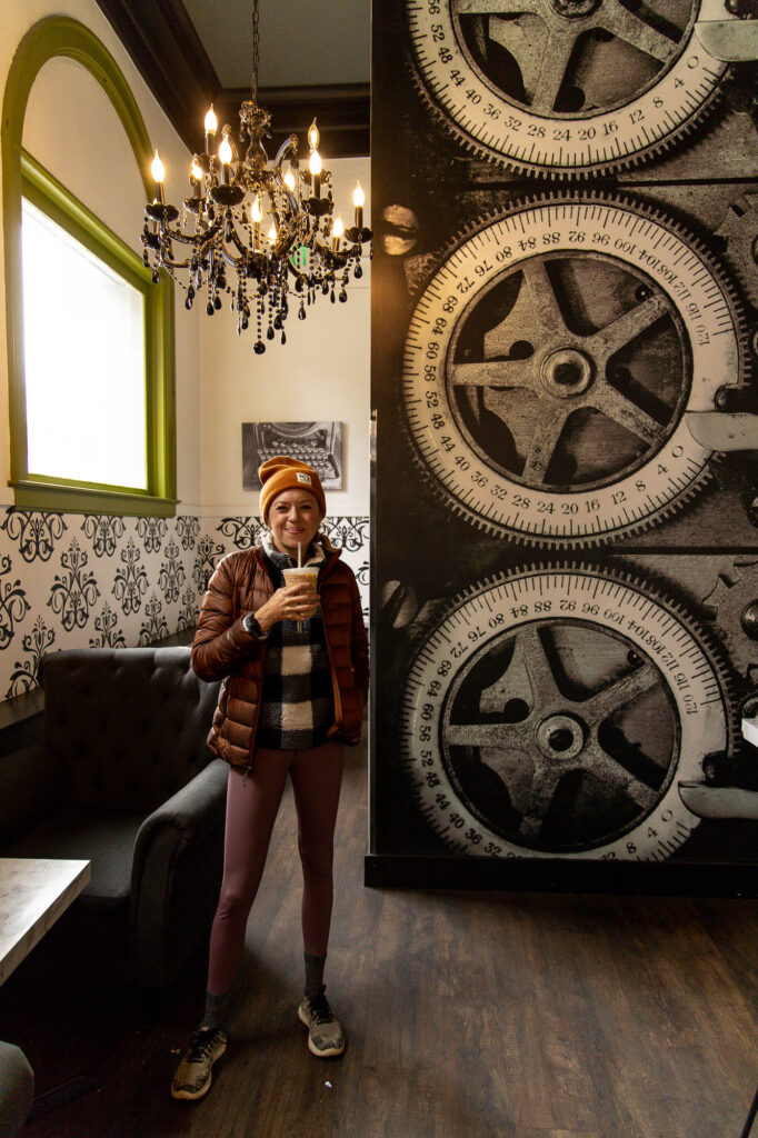 Girl holding a coffee in Vault Coffee shop in Coeur d’Alene