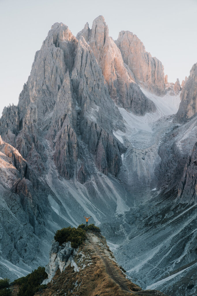 Chelsey Explores at the edge of the Cadini di Misurina hike in the Dolomites which you need to add to your Dolomites road trip