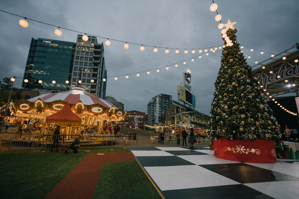 Christmas tree and carasoul all lit up at the San Diego Holiday Market which is one of the best San Diego Christmas events