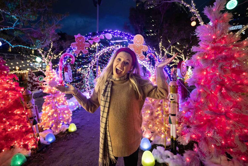 San Diego blogger in front of the Candy Cane Lane display at the Holiday Market Petco Park