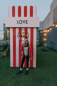 San Diego influencer enjoying a box of popcorn atop the Rooftop Cinema Club 