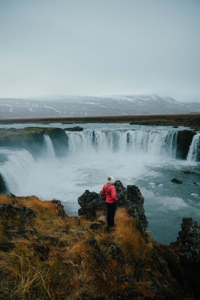 Girl standing in front of Godafoss Waterfall