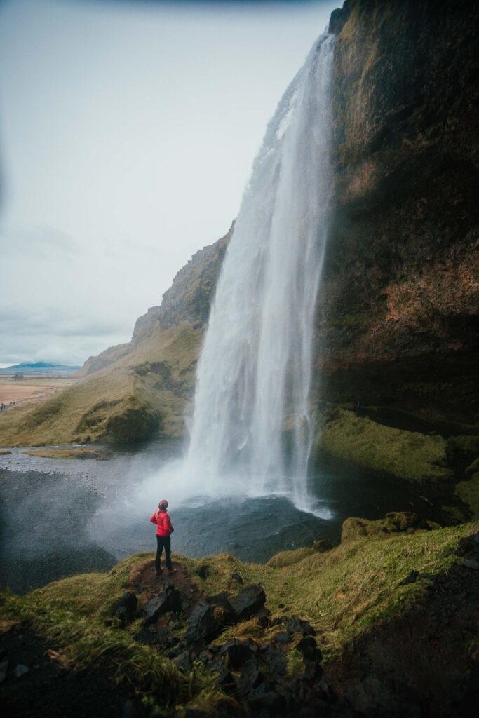 Girl standing in front of Seljalandfoss Waterfall