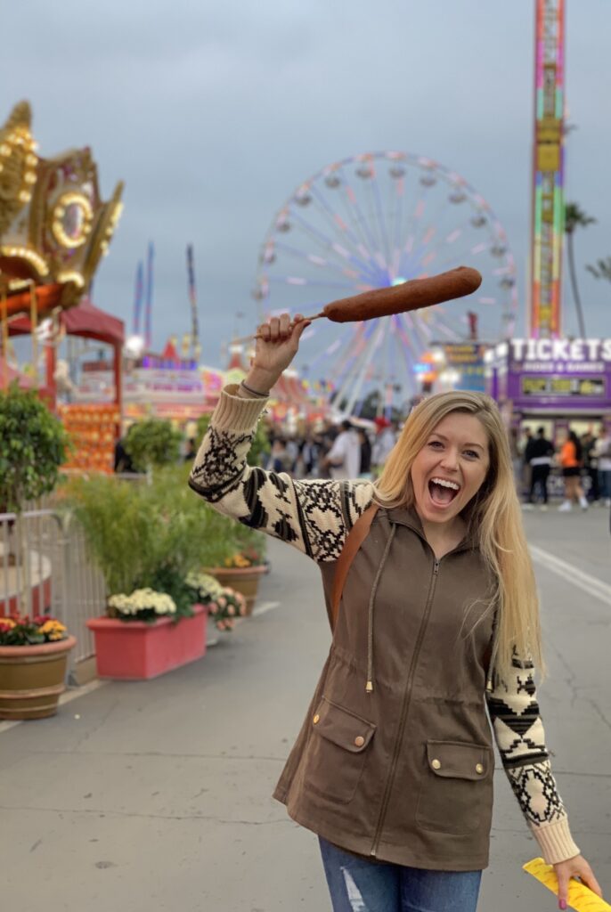 Chelsey holding a corndog at the San Diego county fair