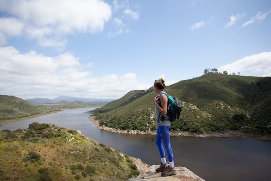 Girl standing on rock looking over Lake Hodges