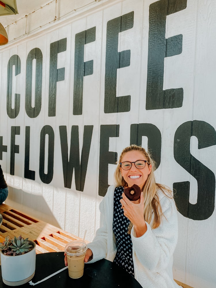 Girl eating a donut and coffee at Communal Coffee shop