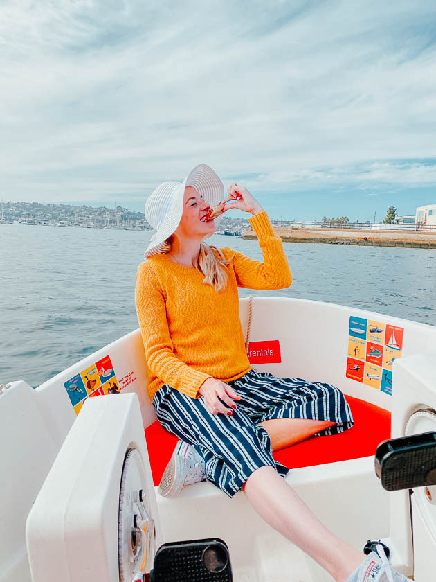 Girl eating pizza on a boat in Point Loma