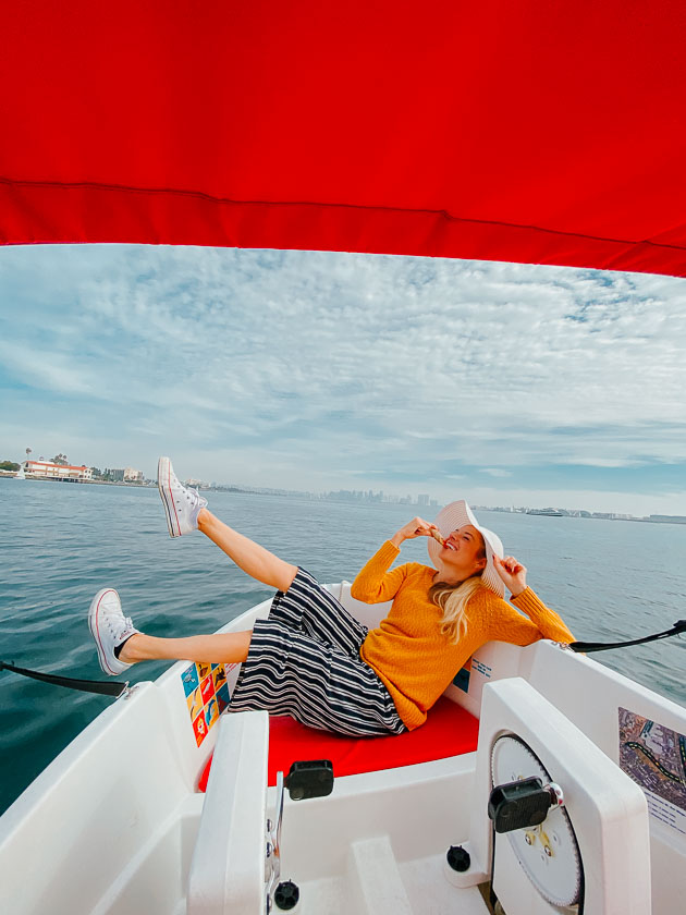 Girl eating pizza on a boat in Point Loma