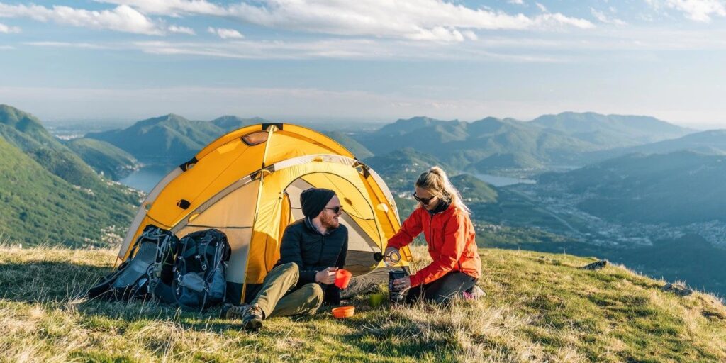couple camping in tent with mountain view