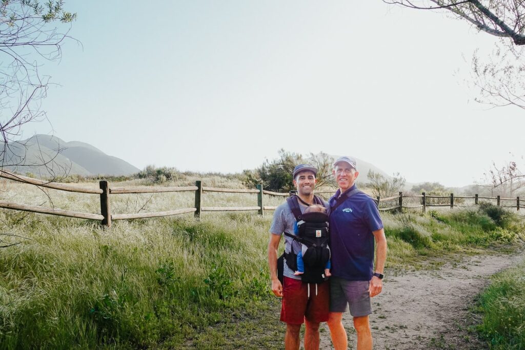 father and son hiking with baby