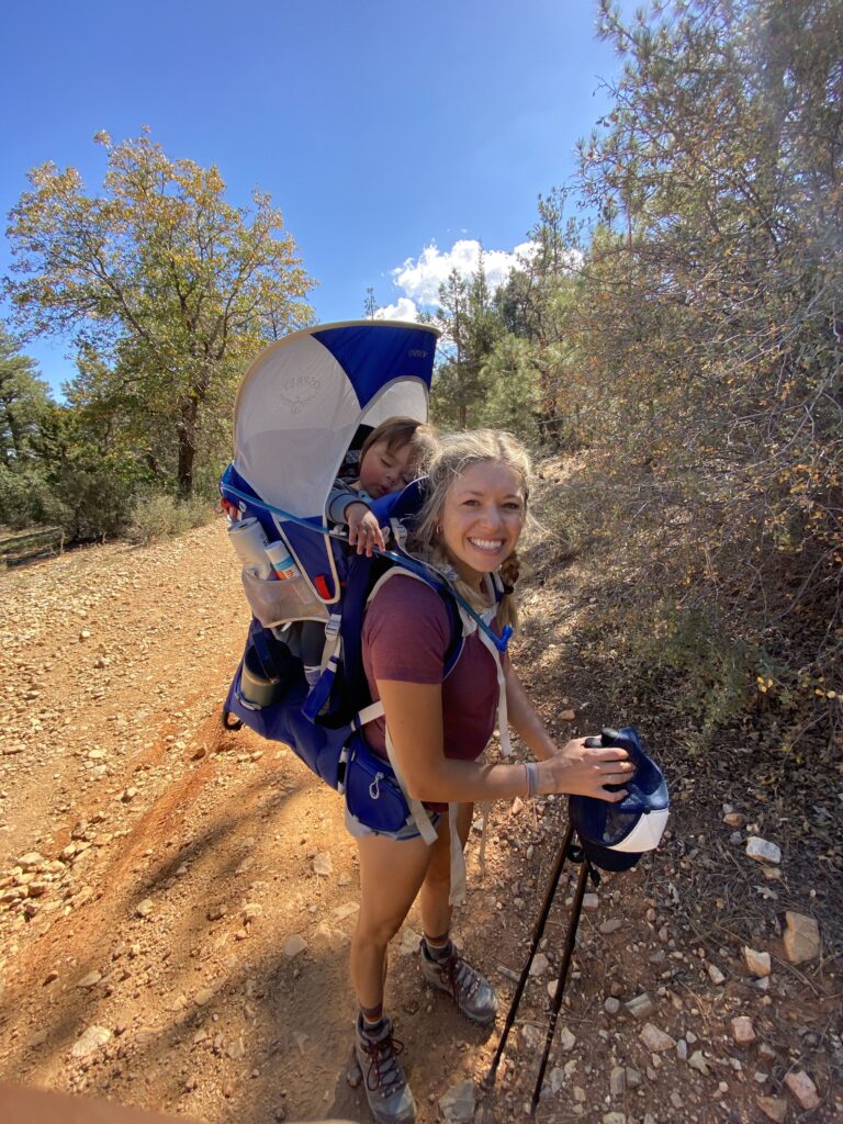 mom hiking with sleeping baby on her back