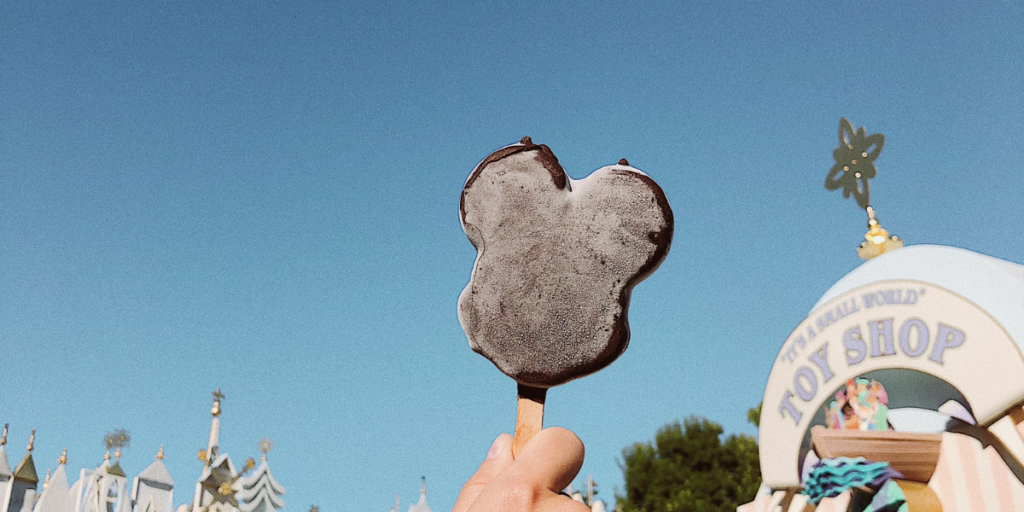 hand holding a mickey mouse ice cream treat