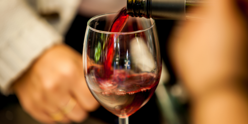 pouring red wine into a wine glass